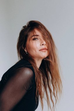 Uzun saçlı ve siyah tişörtlü düşünceli bir kadın..