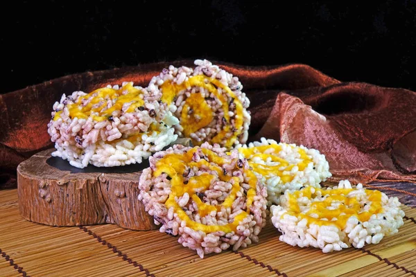 Rice cracker or Khaotan, local famous dessert of traditional ceremony in Northern Thailand, made from white and black glutinous rice and sugar cane syrup. Thai crispy rice cake with cane sugar drizzle