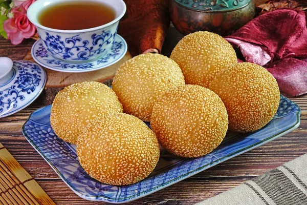 Sesame Ball is fried dessert balls made of flour stuffed with seasoning mung bean, red bean, black bean or peanut paste and coated with white sesame. Also known as Dragon balls, Famous  Chinese snack