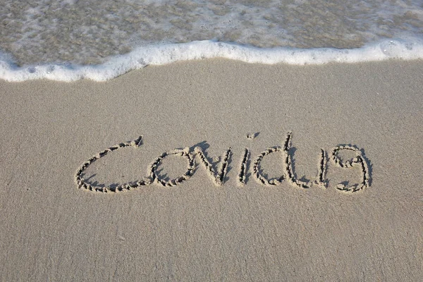 ビーチの砂のメッセージ コヴィト19波とビーチで砂の中に書かれた 概念写真 選択的焦点 — ストック写真