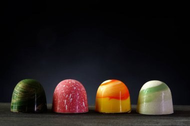 Çikolatalı bonbon. Lüks el yapımı çikolatalı bonbonlar ahşap masa üzerinde gece arkaplanı, kopyalama alanı. 