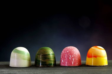 Çikolatalı bonbon. Lüks el yapımı çikolatalı bonbonlar ahşap masa üzerinde gece arkaplanı, kopyalama alanı. 