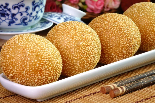 Sesame Ball is fried dessert balls made of flour stuffed with seasoning mung bean, red bean, black bean or peanut paste and coated with white sesame. Also known as Dragon balls, Famous  Chinese snack