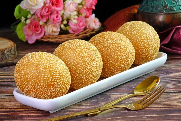 Sesame Ball is fried dessert balls made of flour stuffed with seasoning mung bean, red bean, black bean or peanut paste and coated with white sesame. Also known as Dragon balls, Famous  Chinese snack
