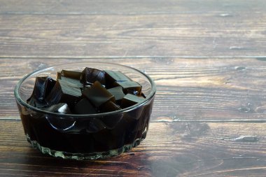 Grass jelly, or leaf jelly or herb jelly, is a jelly-like dessert eaten in East Asia. Dessert of Summer. Selective focus, copy space clipart