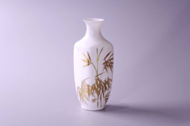 Gri arkaplan üzerine antik Çin yumurta kabuğu porselen vazosu. Beyaz porselen vazodaki altın bambu yaprakları, Çin 'in ünlü antik Ming ve Qing hanedanlığı çömlekleri.
