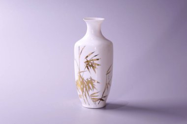 Gri arkaplan üzerine antik Çin yumurta kabuğu porselen vazosu. Beyaz porselen vazodaki altın bambu yaprakları, Çin 'in ünlü antik Ming ve Qing hanedanlığı çömlekleri.