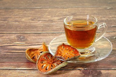 Bangal bıldırcın meyveli bitki çayı. Bael meyvesi antiinflamatuar özelliğe sahiptir, sindirim bozukluklarını iyileştirmeye yardımcı olur, astım için ilaç olarak kullanılır ve nezle için de kullanılır. Kopyalama alanı ile seçmeli odak.