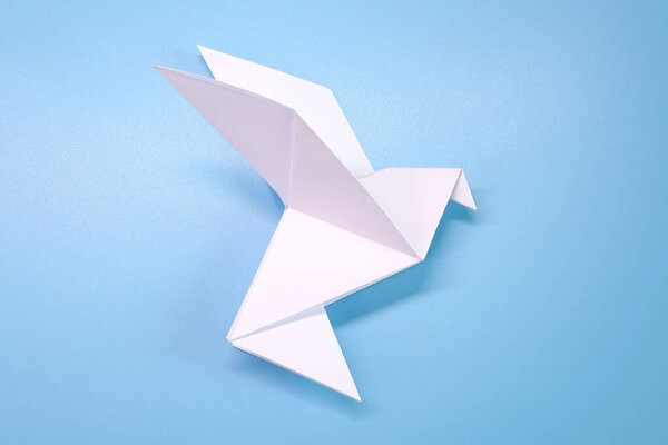 Origami : Flying dove on blue background. Concepts photo for help fight against COVID-19 campaign, symbol of peaceful