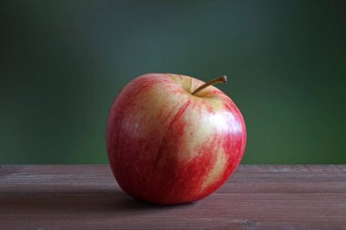 Ahşap masada organik gala elması. Seçici odak, bulanık doğa yeşil arkaplan.