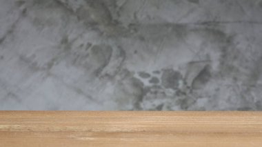 Bulanık ham beton (Beton brut) içeren boş ahşap masa, ürünleri veya yiyecekleri görüntülemek için montaj için kullanılır. Seçici odak.