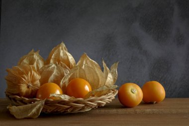 Taze Gooseberry Burnu (Physalis Peruviana) ahşap sepetin üzerinde. Kopya uzayı ile bulanık beton (Beton Brut) arka plan. natürmort.