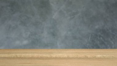 Bulanık ham beton (Beton brut) içeren boş ahşap masa, ürünleri veya yiyecekleri görüntülemek için montaj için kullanılır. Seçici odak.