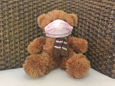 Maske takan oyuncak ayı, çocukları Coronavirus 'a yakalanmaktan korumak için çocukları maske takmaya ikna edecek fikirler. Seçici odak.