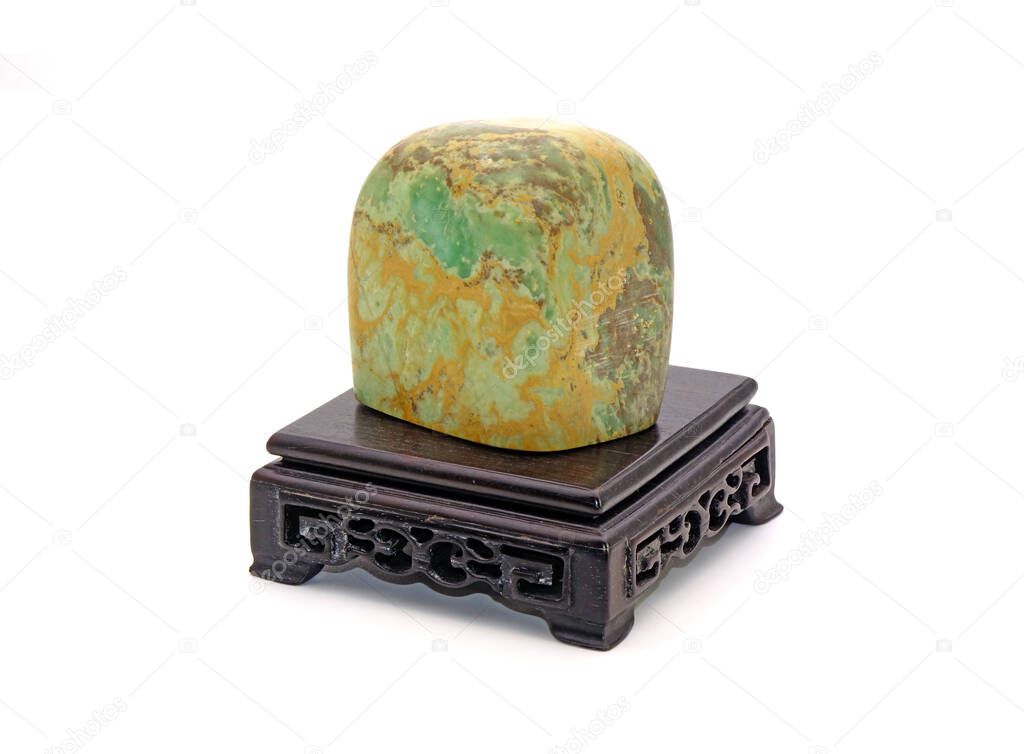 Chinese gemstone (Shou Shan Shi) on wooden stool Isolated on white background. symbol of longevity, happiness and wealth in Chinese, Japanese and Korean culture.