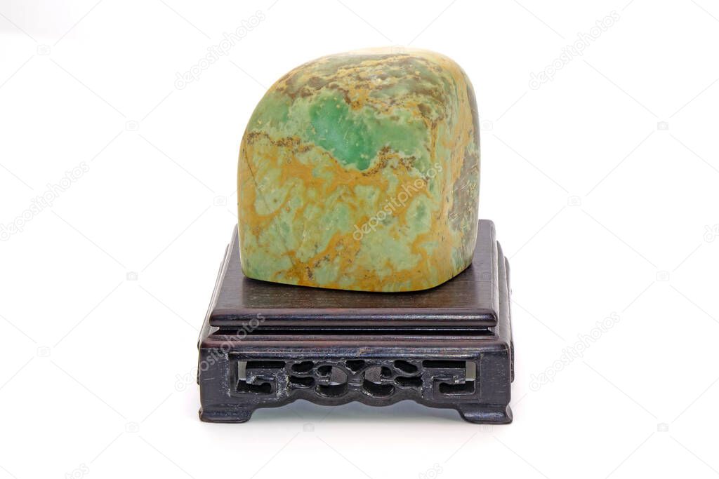 Chinese gemstone (Shou Shan Shi) on wooden stool Isolated on white background. symbol of longevity, happiness and wealth in Chinese, Japanese and Korean culture.