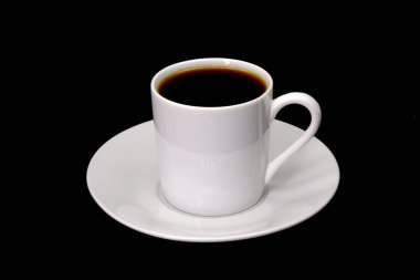 Siyah arka planda izole edilmiş beyaz fincanda koyu kahve.