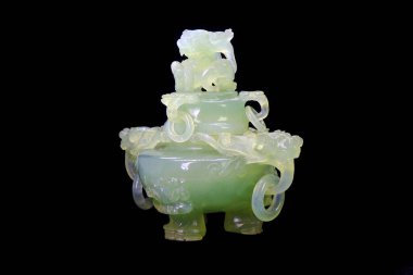 Çin antikası oyulmuş yeşil nephrite yeşim taşı merkezli üç ayaklı tütsü yakıcı siyah arka planda izole edilmiş.