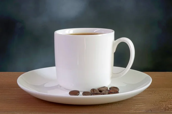 Μαύρο Καφέ Λευκό Κύπελλο Καβουρδισμένους Κόκκους Καφέ Ξύλινο Τραπέζι Θολή — Φωτογραφία Αρχείου