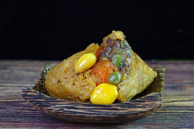 Yapışkan pirinç köftesi ya da Zongzi, bambu yapraklarıyla doldurulmuş ve Ejderha Teknesi Festivali (Duanwu Festivali) için bambu yapraklarına sarılmış geleneksel Çin pilav tabağıdır.)