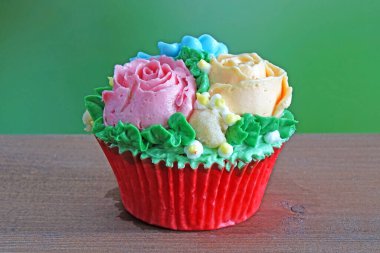 Kore tarzı renkli çiçekler ahşap masada krem rengi kek. Seçici odak, kopyalama alanı ile bulanık arkaplan