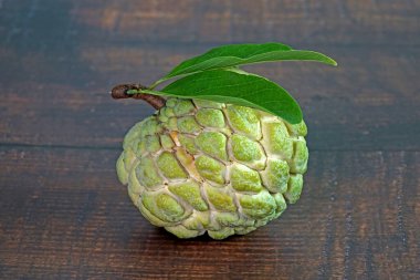 Elma şekeri, elma şekeri ya da krema, Annona squamosa 'nın meyvesidir. Seçici odak, kopyalama alanı ile bulanık ahşap arkaplan.