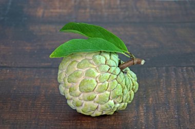 Elma şekeri, elma şekeri ya da krema, Annona squamosa 'nın meyvesidir. Seçici odak, kopyalama alanı ile bulanık ahşap arkaplan.