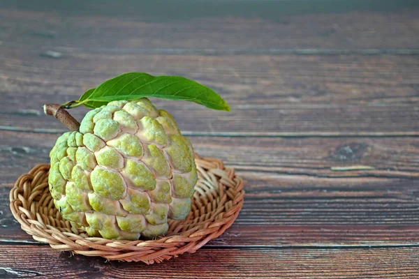 Elma şekeri, elma şekeri ya da krema, Annona squamosa 'nın meyvesidir. Seçici odak, kopyalama alanı ile bulanık ahşap arkaplan.