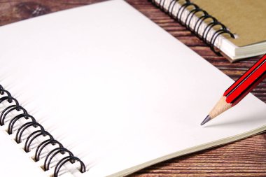 Defter ve kalem. Kavram fotoğrafçılığı için kurşun kalemli boş defter kağıdı. Seçici odak, boşluğu kopyala