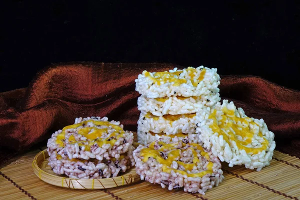 Rice cracker or Khaotan, local famous dessert of traditional ceremony in Northern Thailand, made from white and black glutinous rice and sugar cane syrup. Thai crispy rice cake with cane sugar drizzle