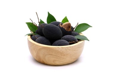 Beyaz arka planda izole edilmiş ahşap kasede kadife demirhindi. Siyah Kadife Tamarind (Dialium Cochinchinense)