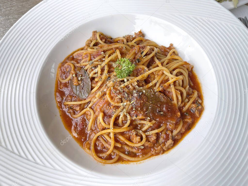 Espaguetis boloñeses en plato blanco, enfoque selectivo. La salsa