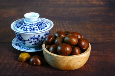 Kestane: Ahşap kasede Çin çayıyla servis edilen kavrulmuş kestane.