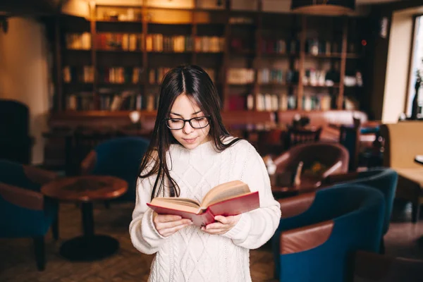 Młody student dziewczyna czytania książki w bibliotece — Zdjęcie stockowe