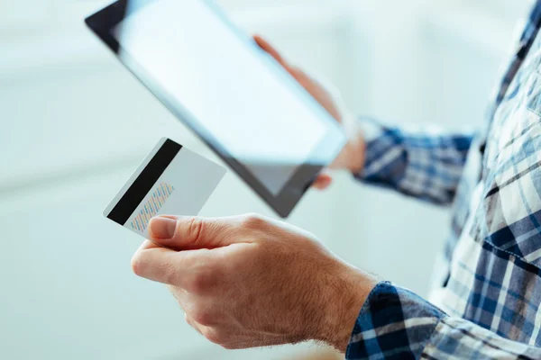 Mains masculines tenant une carte de crédit et une tablette — Photo