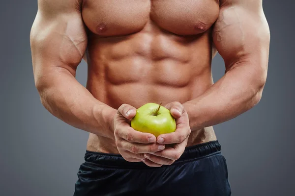 Hemdsloser Bodybuilder mit einem Apfel in der Hand — Stockfoto