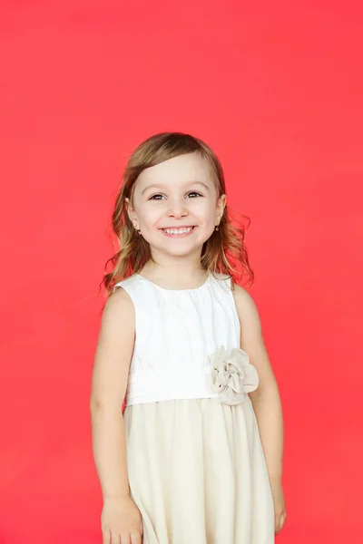 Χαριτωμένο κοριτσάκι σε λευκό φόρεμα που χαμογελά στη φωτογραφική μηχανή — Φωτογραφία Αρχείου