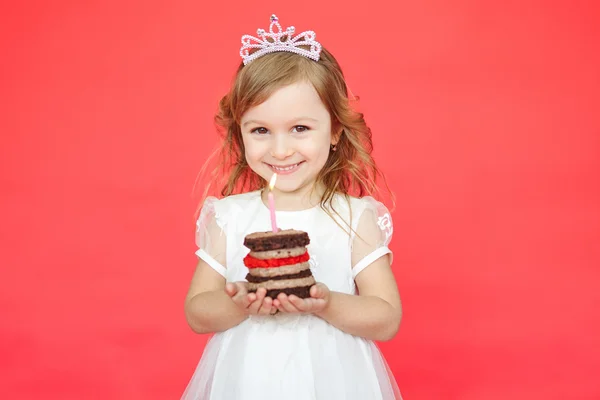 Kis lány visel korona gazdaság egy születésnapi torta — Stock Fotó