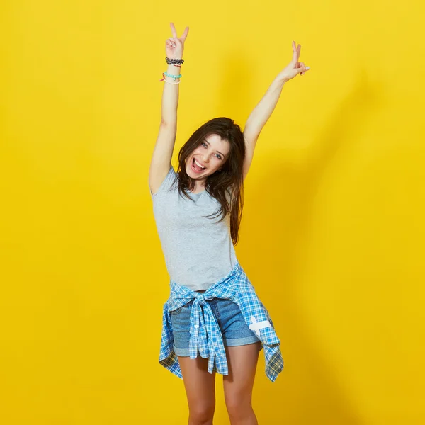 Jong meisje verspreiding handen geïsoleerd op gele achtergrond — Stockfoto