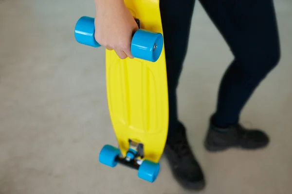 Nahaufnahme eines Mädchens mit gelbem Longboard. — Stockfoto