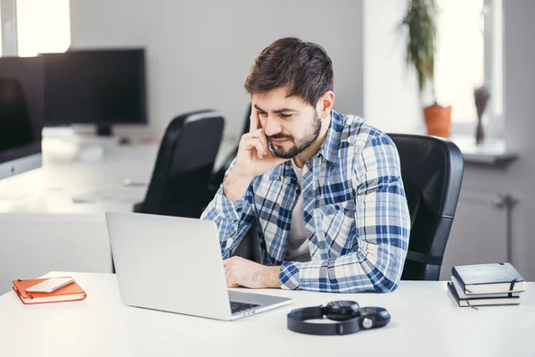 Frustrierter junger bärtiger Mann denkt und sitzt — Stockfoto