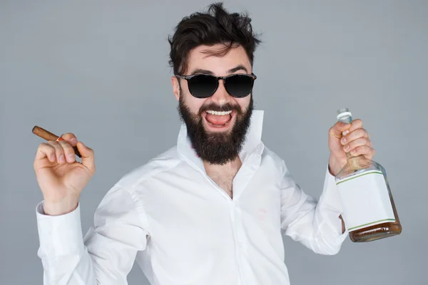Человек с бутылкой виски и сигарой — стоковое фото