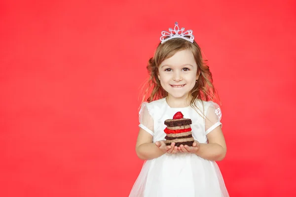 Menina bonito garoto segurando um saboroso mini bolo — Fotografia de Stock