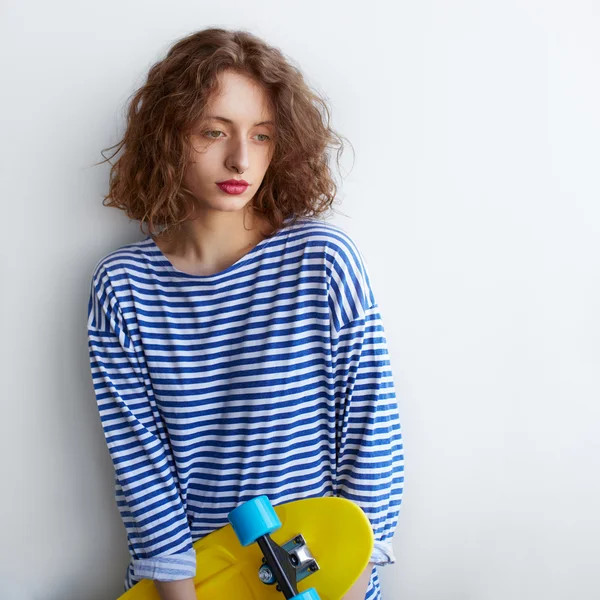 Ziemlich trauriges Hipster-Mädchen mit Skateboard — Stockfoto