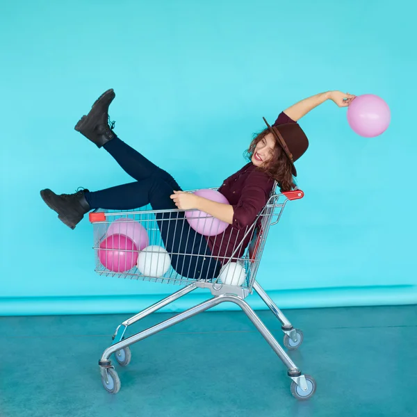 Chica sentada en el carrito de compras — Foto de Stock