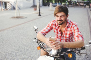 Cep telefonu üzerinde gülümseyen genç adam manifatura