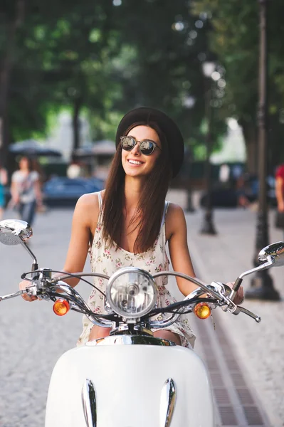 Молодая веселая девушка за рулем скутера — стоковое фото