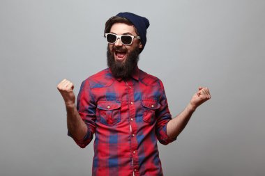 happy hipster man with beard exults clipart