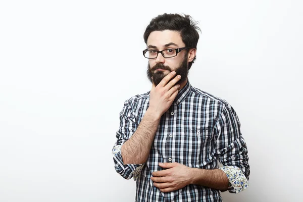 Homem de óculos tocando sua barba e pensando — Fotografia de Stock