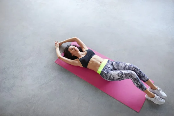 Top view portrait of a young woman lying on the yoga mat — Stock Photo, Image